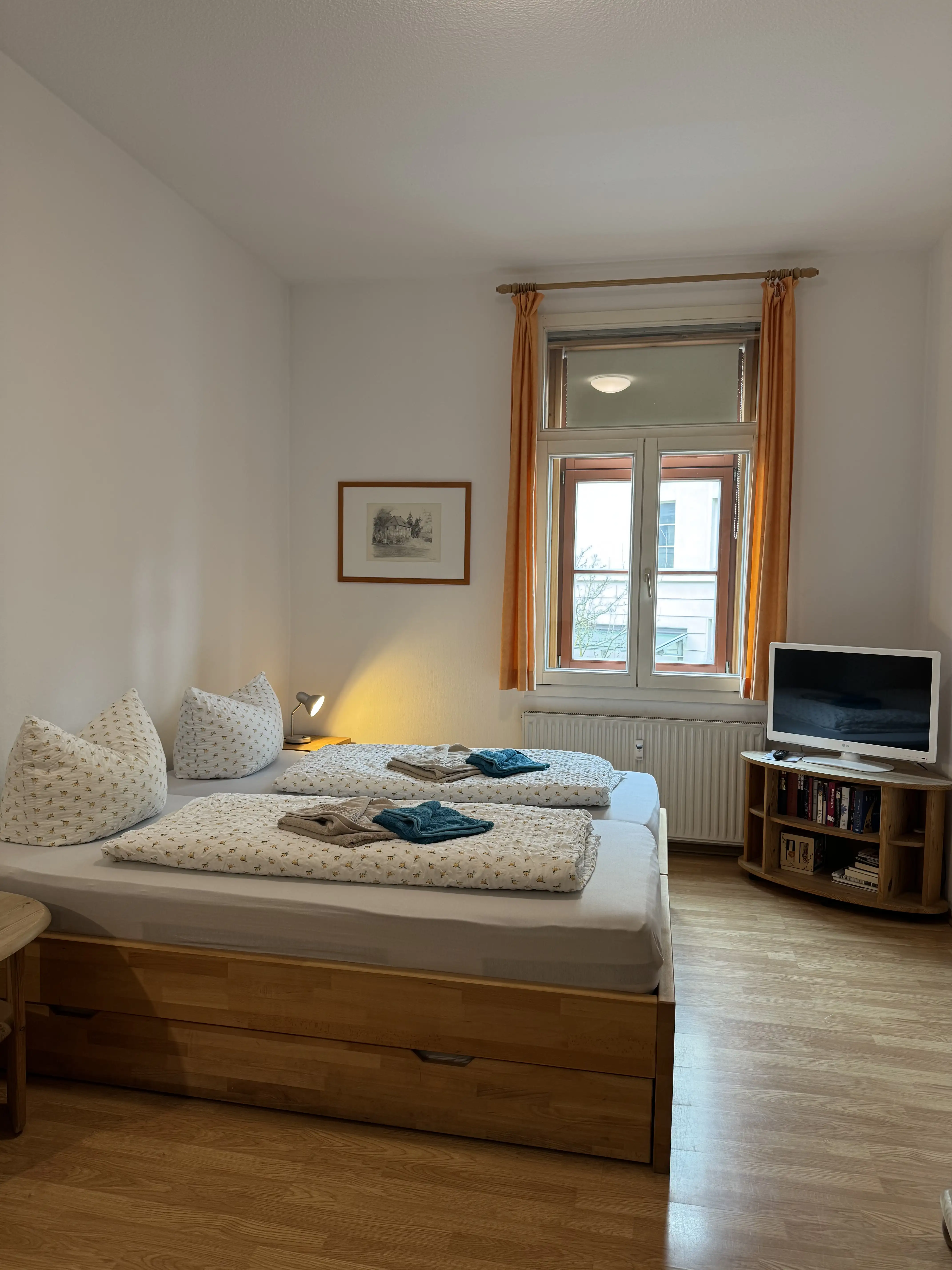 Schlafzimmer mit einem Doppelbett und einem Fernseher im Appartement für zwei Personen in Weimar